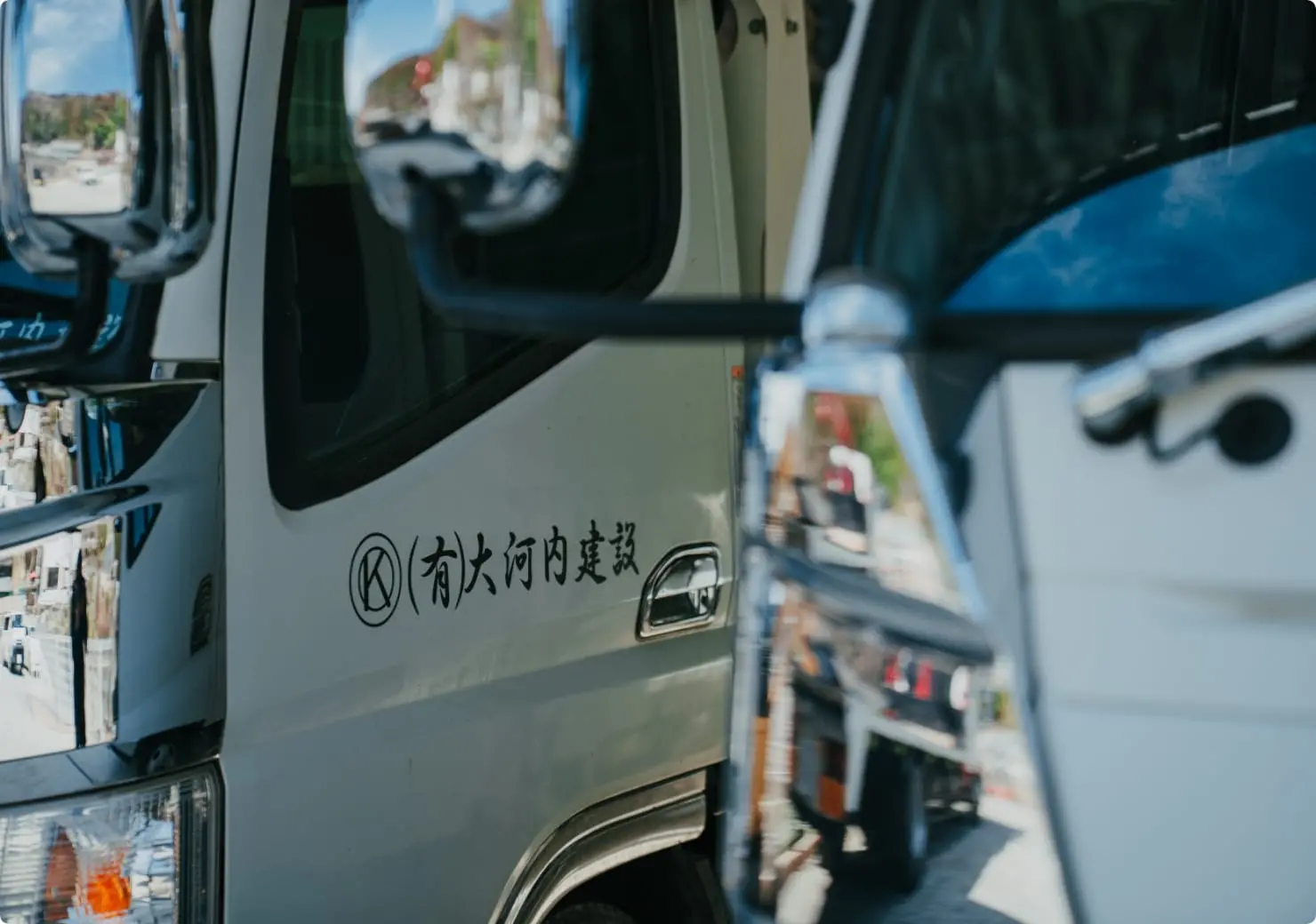 『有限会社 大河内建設』のロゴが入った白い作業車。